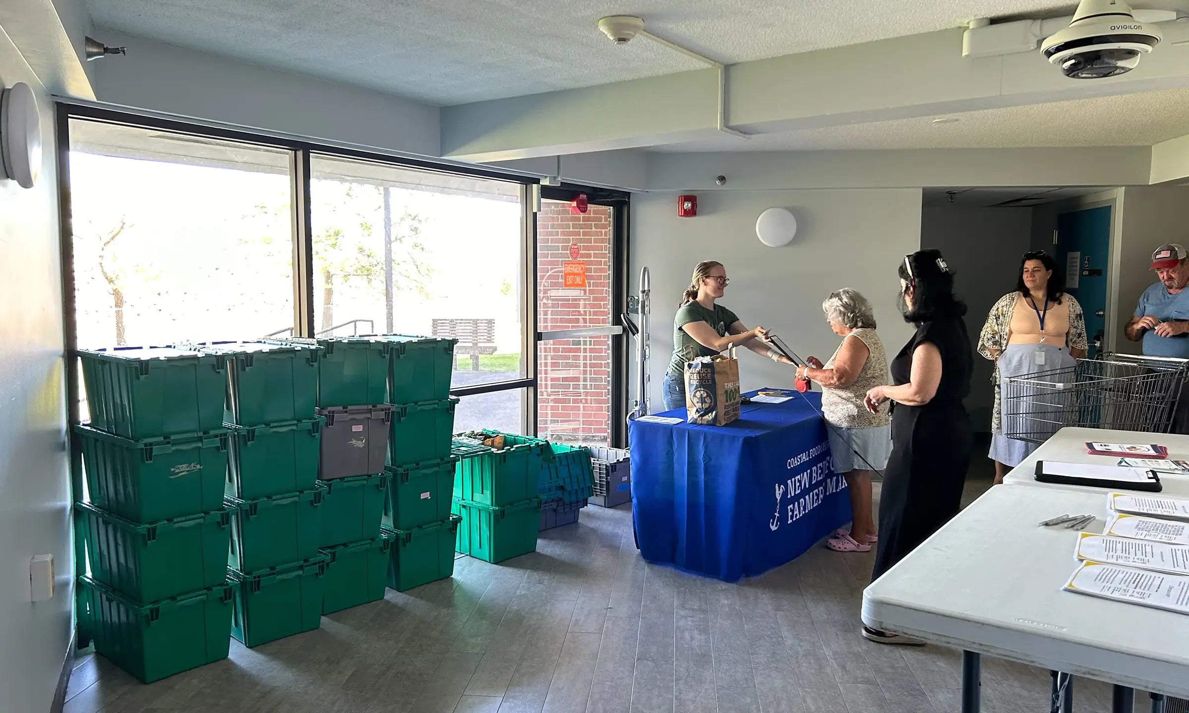 HIP Delivery Program inside Coastal Foodshed, woman taking orders from behind table