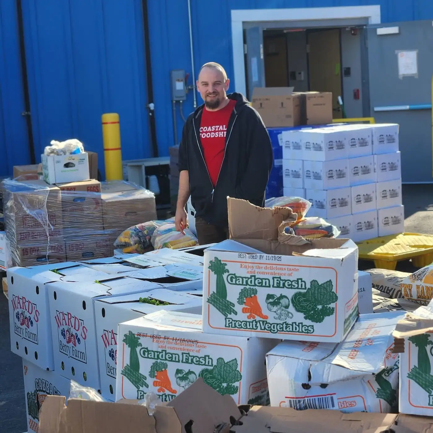 Coastal Foodshed worker pictured with wholesale produce outside